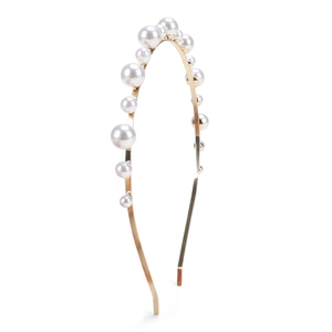 Macro detail of elegant golden metal headband with white pearls for bridal wedding hairstyle