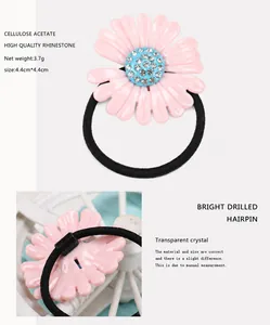 Detailansicht vom rosa Gänseblümchen-Haargummi mit Azetatblüten und blauem Kristall