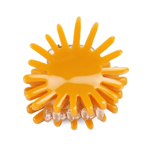 Detail view of yellow sun-shaped hair claw clip with glossy finish and spring mechanism