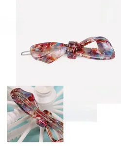 Macro detail of cellulose acetate bow hair clip showing material texture and clip size