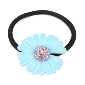 Detailed view of light blue resin daisy charm with pink crystal center on black hair tie
