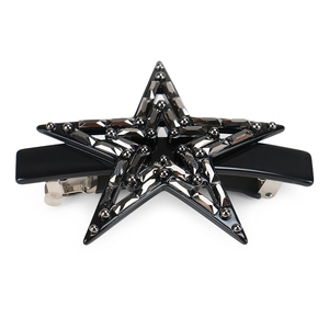 Detail view of the black star-shaped hair clip with shimmering crystals and silver rivets