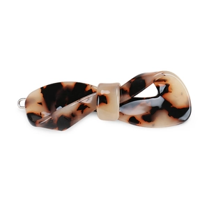 Detail view of a tortoise shell patterned acetate bow hair clip with glossy resin finish