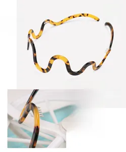 Detail view of wavy acetate headband with tortoiseshell pattern and inner comb teeth