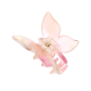 Détail de la pince à cheveux papillon en acétate dégradé rose avec ressort doré