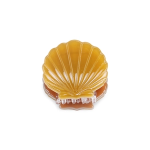 Detail view of mini shell hair claw clip in amber acetate with textured ridges