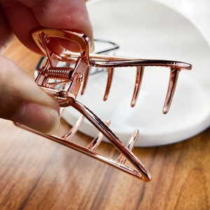 Detail of rose gold alloy claw clip with strong spring and metallic polished finish