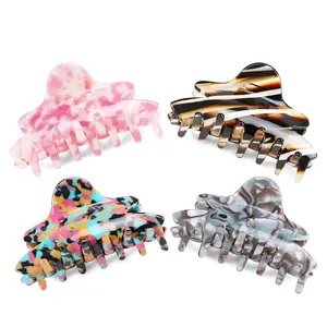 Set of four stylish acetate hair claws in marble, tortoiseshell, and floral patterns