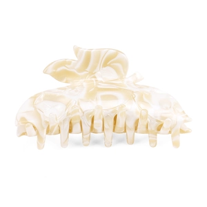 Close-up of leaf-shaped acetate hair claw clip with cream white marble texture pattern