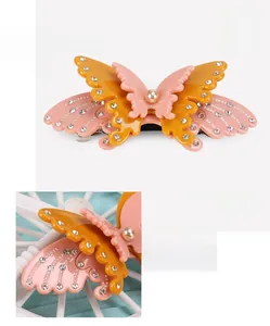 Macro shot of double-layer acetate bow hair clip with embedded rhinestones and pearl