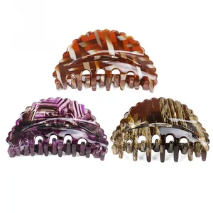 Three acetate hair claws set in tortoiseshell, purple marble, and black gold patterns