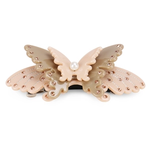 Detailed macro view of layered acetate butterfly hair clip with rhinestones and pearl bead