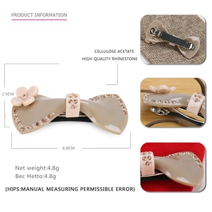 Barrette nœud en acétate marron avec strass brillants et détail de fleur rose