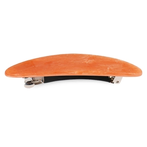 Detail view of glossy orange acrylic hair clip with metallic spring fastener