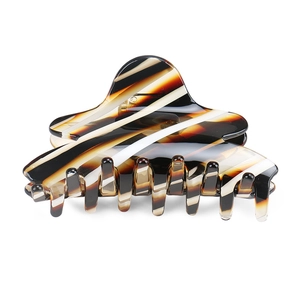 Detail view of large acetate hair claw clip featuring stylish tortoiseshell diagonal stripes