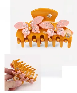Detail showing orange cellulose acetate bow hair claw with pink rhinestone butterflies
