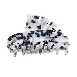 Macro view of large acetate hair claw clip showing black and white marble texture details
