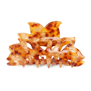 Detail of large acetate hair claw clip featuring brown tortoise shell pattern and petal shape