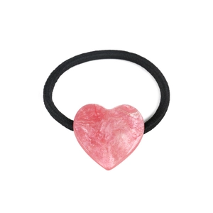 Detail of pink resin heart hair tie showing white marble texture and gold glitter sparkles