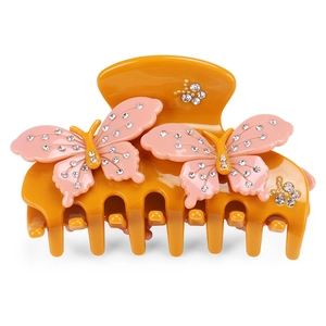 Close-up of acetate claw clip with pink butterfly motifs and sparkling rhinestones