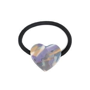 Detail of heart-shaped marble acetate charm on a black high-elastic hair tie for ponytails
