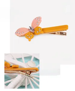 Detail of orange and pink acetate butterfly hair clip with rhinestones and metal clip