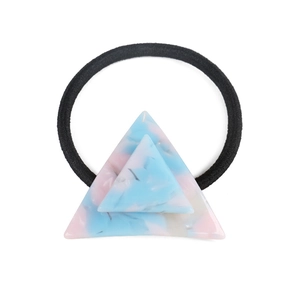 Close-up of geometric acetate hair tie with blue pink marble pattern triangles
