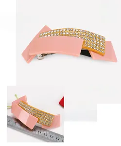 Detail of pink and yellow acetate geometric hair clip with sparkling rhinestones and size guide