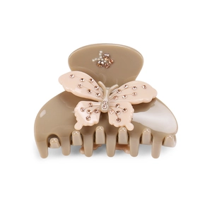 Close-up of beige acetate hair claw clip featuring rhinestones and faux pearl butterfly