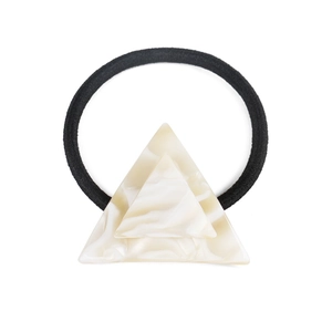 Close-up of geometric triangle acetate hair tie with ivory marble texture and black band