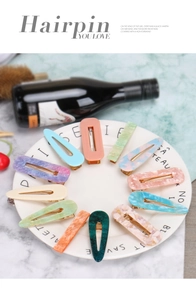 Detail of colorful acetic acid rectangular and drop hairpins in decorative tray