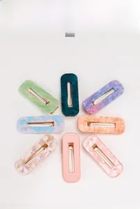 Flat lay of 8-piece set of rectangular acetate hair clips in various vibrant colors