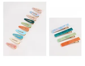 Detail of acetate rectangular hair clips with marble texture and golden metal bases