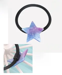 Close-up of a blue star-shaped hair tie made of cellulose acetate with sparkly detail