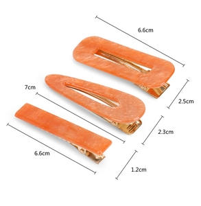 Three-piece orange acetate hair clip set with marble pattern and golden metal clips