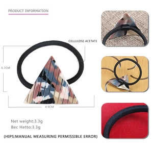 Macro detail of geometric triangle hair tie showing acetate texture and 4.9cm size
