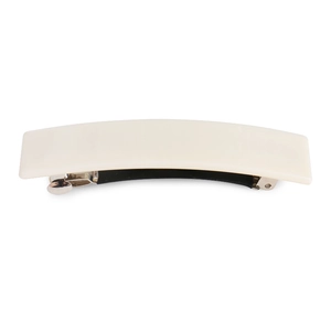 Detail view of the silver metal spring mechanism inside the cream acrylic hair clip