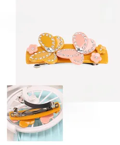 Macro detail of yellow acetate bow hair clip with crystals and silver spring metal clip