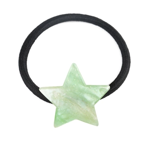 Close-up of black elastic hair tie with a translucent green glitter star charm