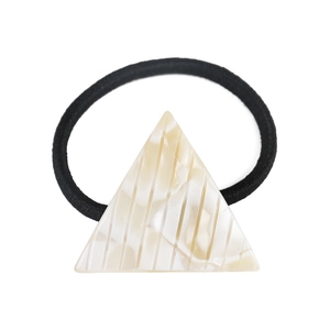Detail of triangle acetate hair tie featuring cream marble texture and vertical engraved lines