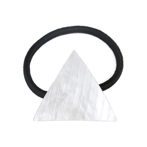 Detail of a pearl white acetate triangle charm on a black high-elastic hair tie