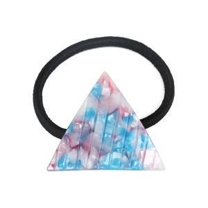 Close-up of geometric triangle hair tie with pink and blue marble pattern on black elastic