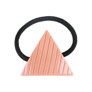Macro detail of a pink triangular acetic hair tie with textured stripe patterns
