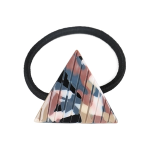 Detail of a geometric acetate hair tie showing marble camouflage texture and vertical grooves