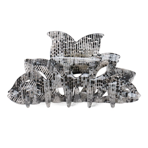 Detailed view of acetic acid butterfly hair claw clip with black and white mosaic pattern