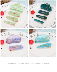 Detailed view of marble acetate hair clips with gold sun and moon patterns in set