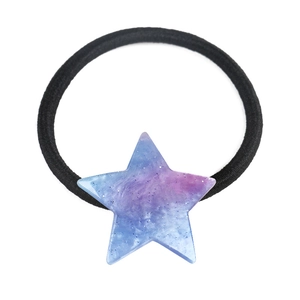 Detailed macro view of black elastic hair tie with a resin star-shaped galaxy charm