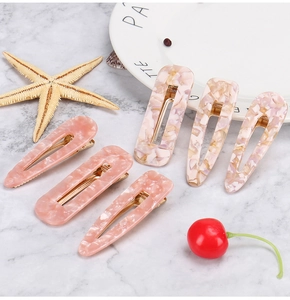 Set of 6 acetate hair clips in pink marble and beige lavender patterns on marble surface