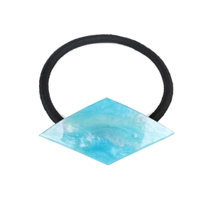 Detail of teal geometric hair tie with resin glitter finish and black elastic cord