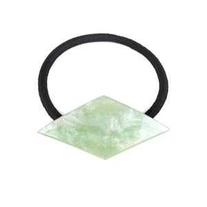 Macro detail of elastic hair tie with green marble-textured geometric acetate charm